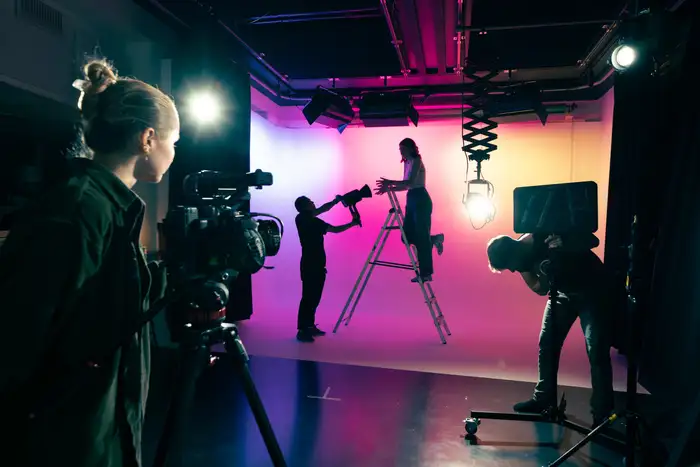 Filmcrew i arbeid på cyclorama med fargelys i studioet