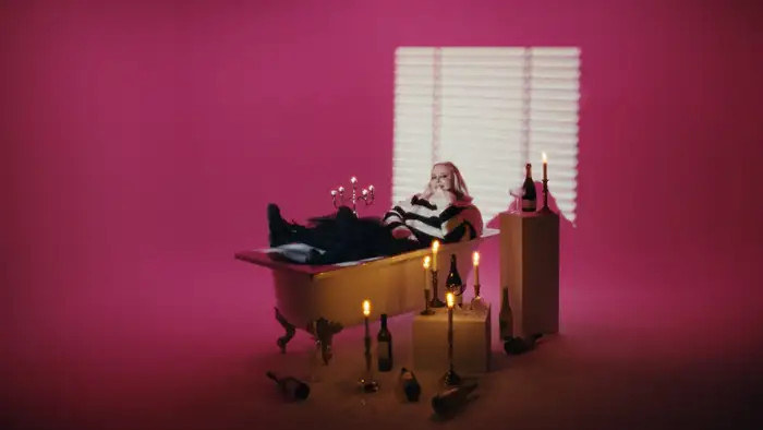 Musikkvideo-set med badekar og rosa lyssetting